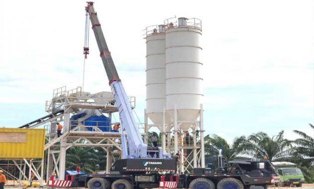 mobil crane sedang mengangkut barang